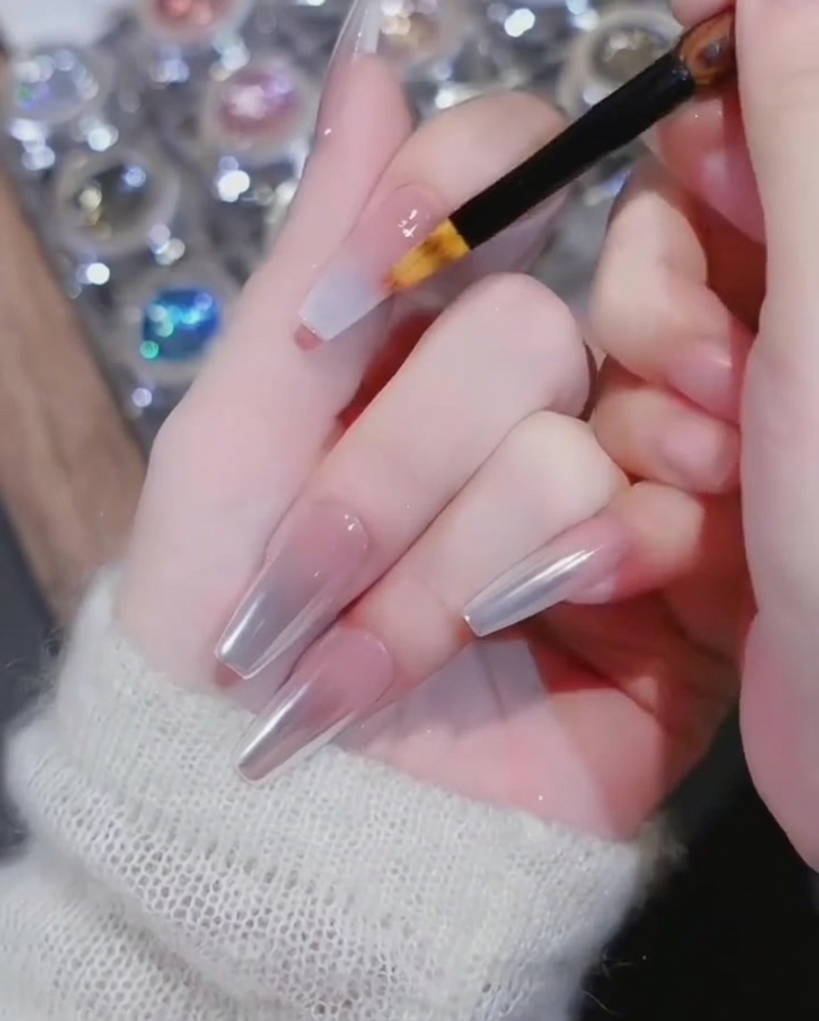 A gradient brush blending the white gel towards the base of the nail.