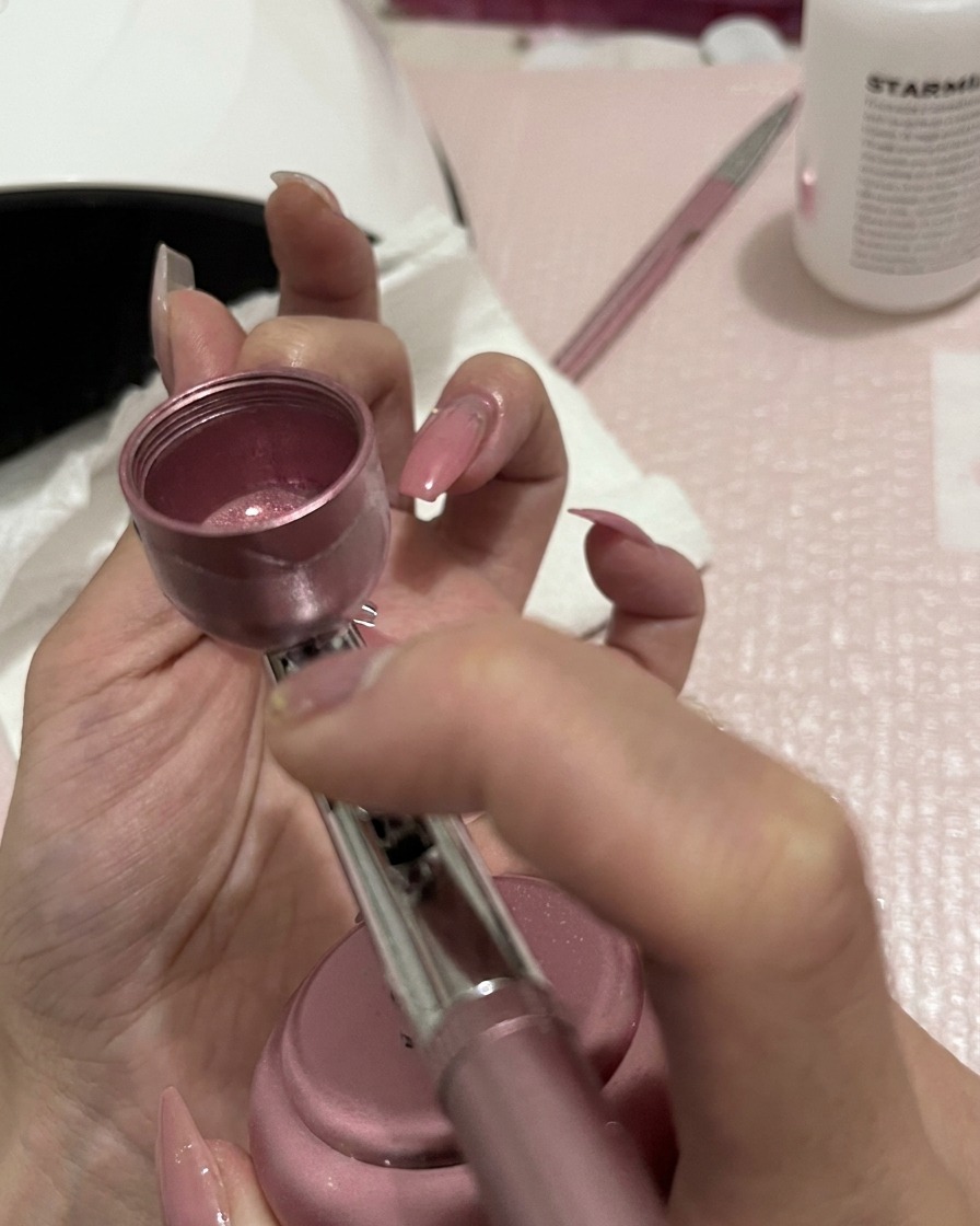 Refining the gradient on the nail with a light, even spray pass toward the free edge.