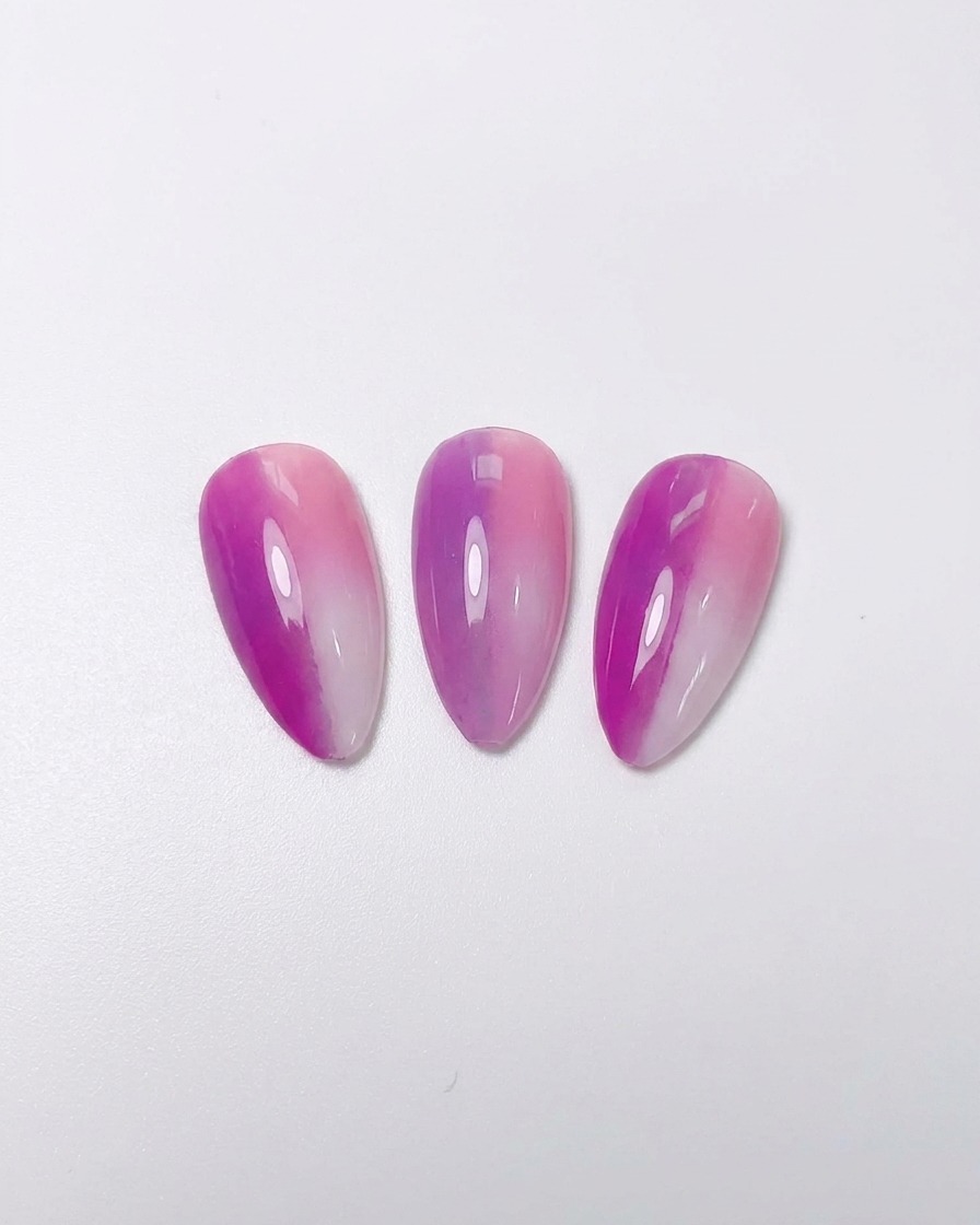 A set of plain white artificial nail tips organized neatly on a clear adhesive strip.