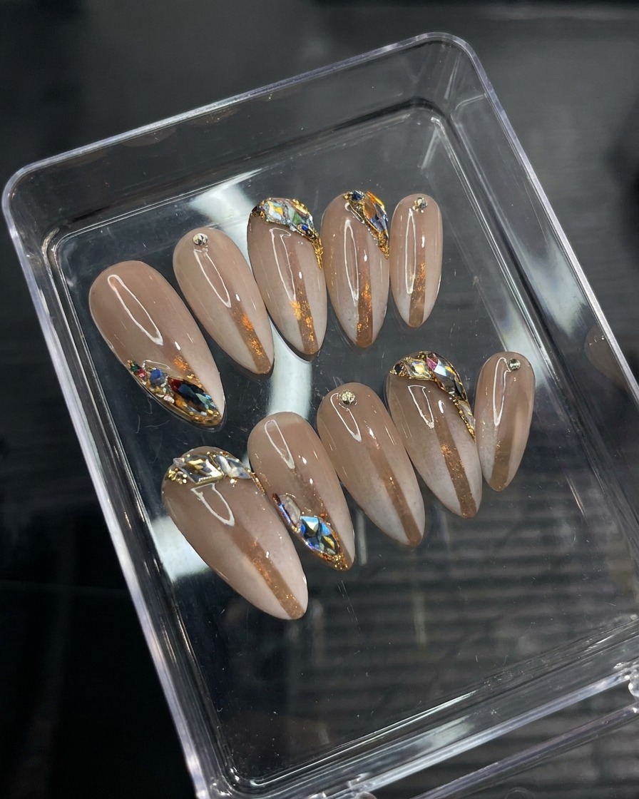 A close-up view of a detail brush placing small decorative gems onto a gel-painted nail surface.