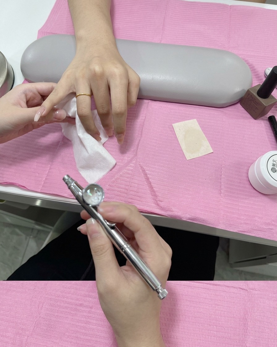 A close-up of a stencil being lifted from a nail, revealing a crisp and clean white gradient tip.