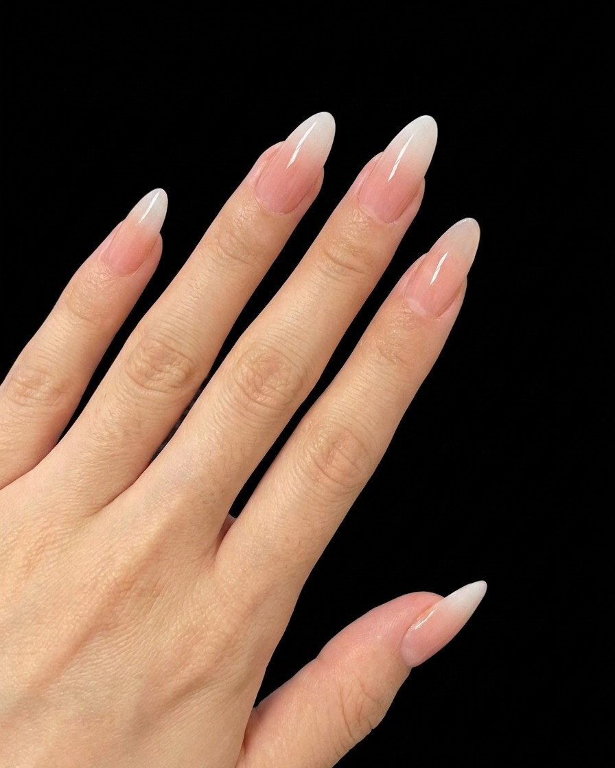 A nail brush applying a small amount of fine glitter gel to the center of a fingernail.