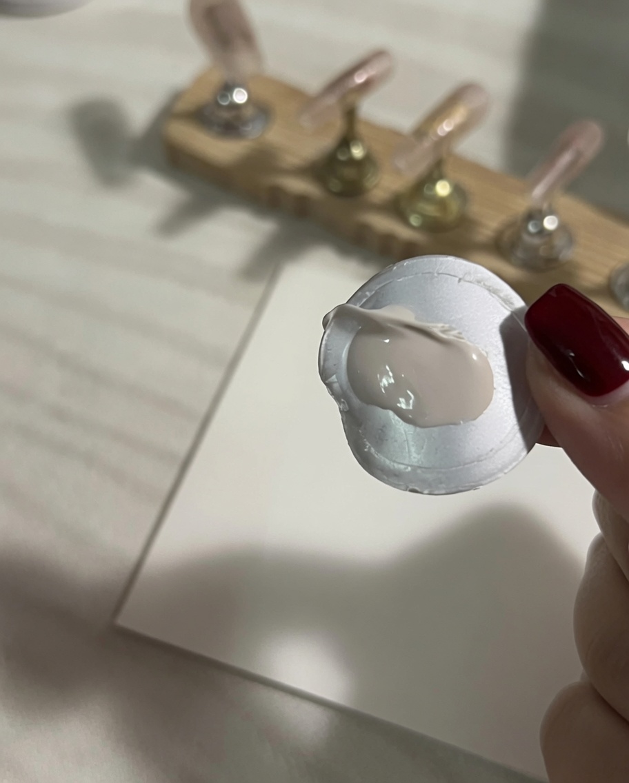 A dollop of thick white gel art paint freshly applied onto a clean white silicone mixing palette paper.