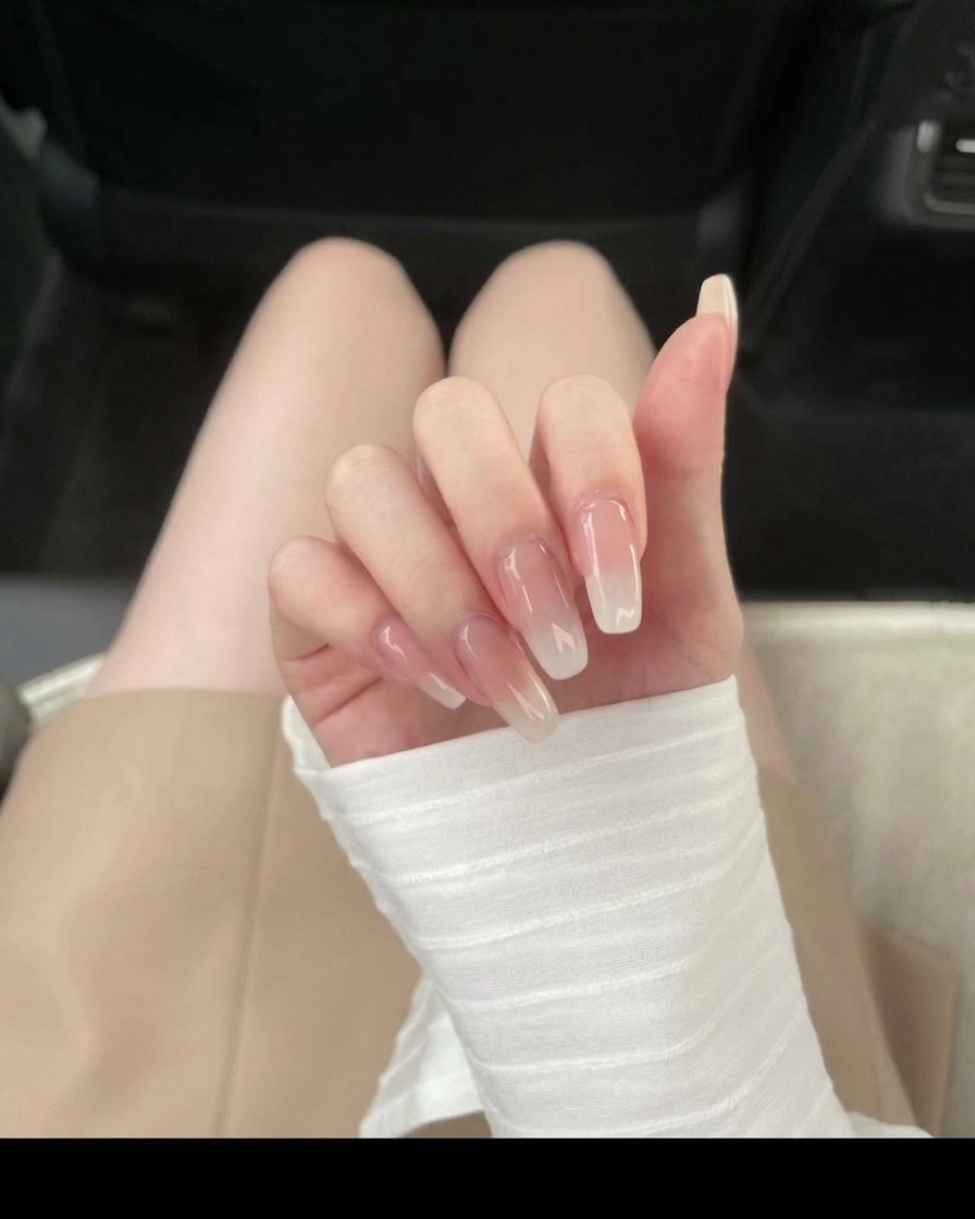 Applying translucent ice nude gel polish to the nail surface.