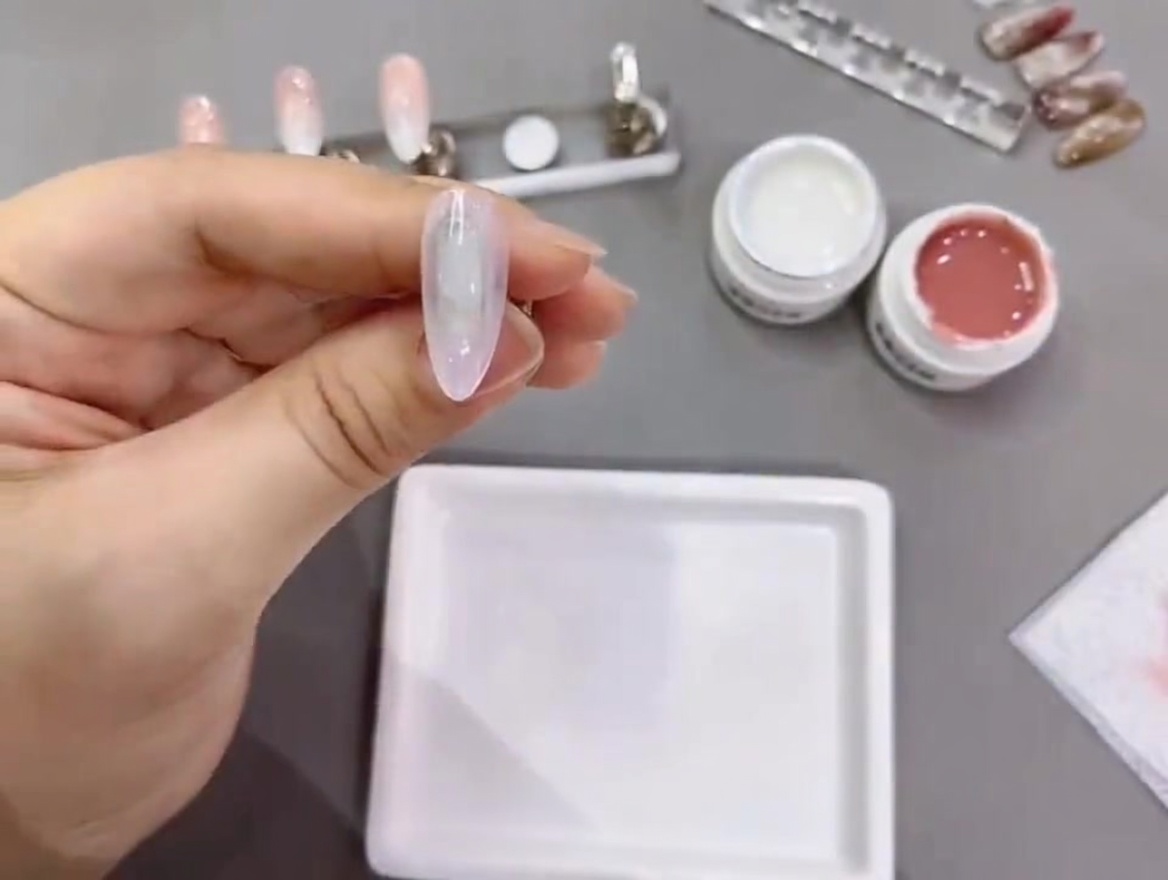A nail tip being cured under a professional UV/LED lamp.