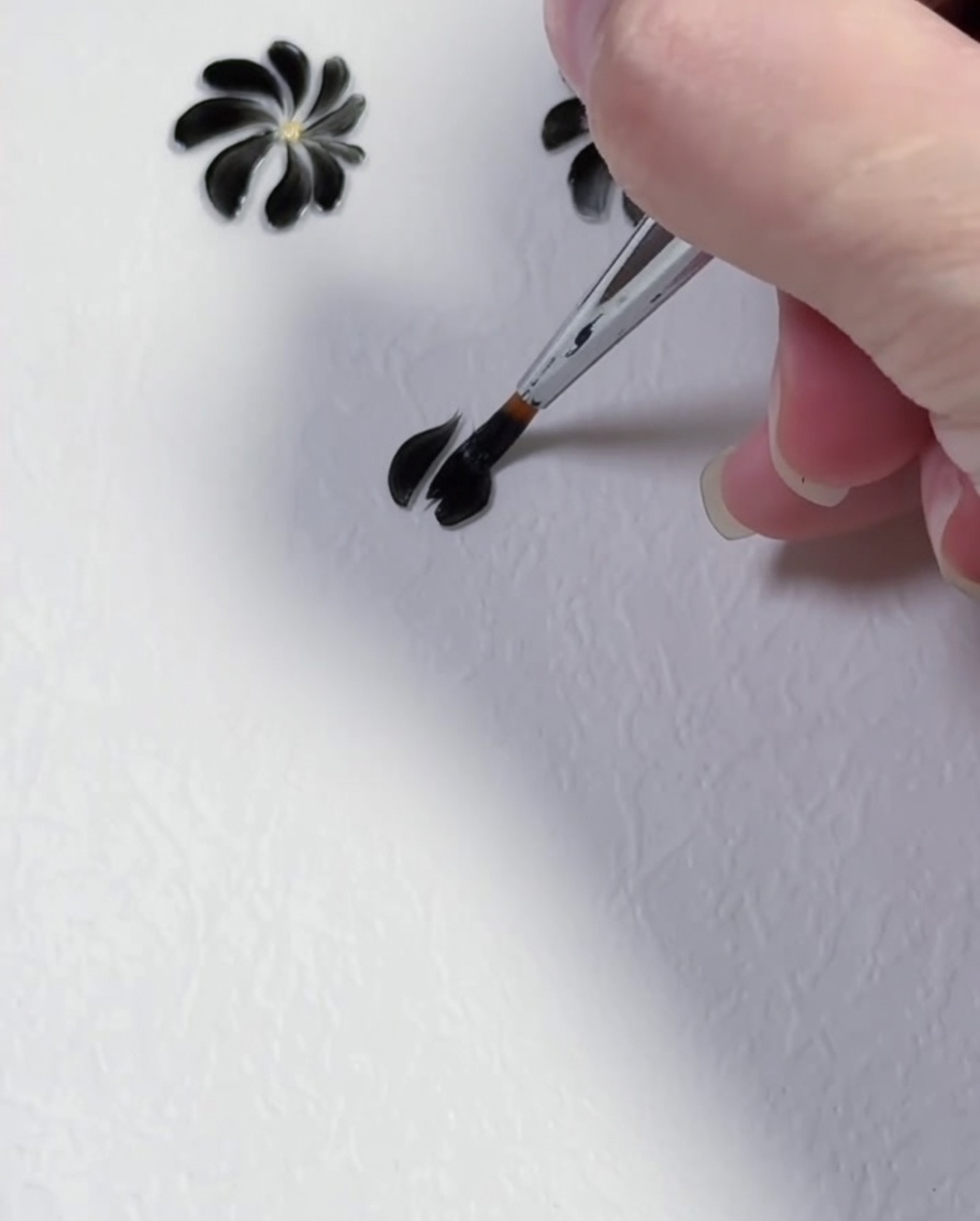 A fine liner brush creating the second black gel petal on a white background.