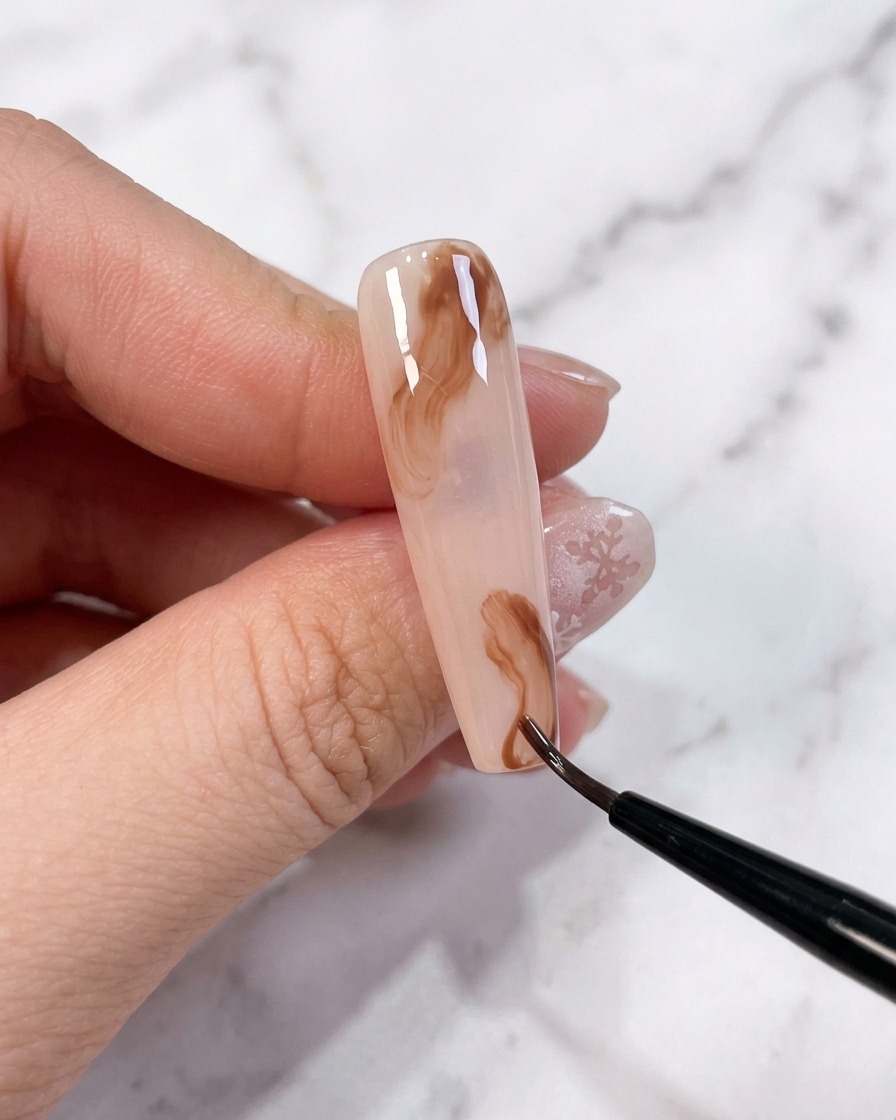 Two small dots of brown gel placed on a nail surface with an uncured base.
