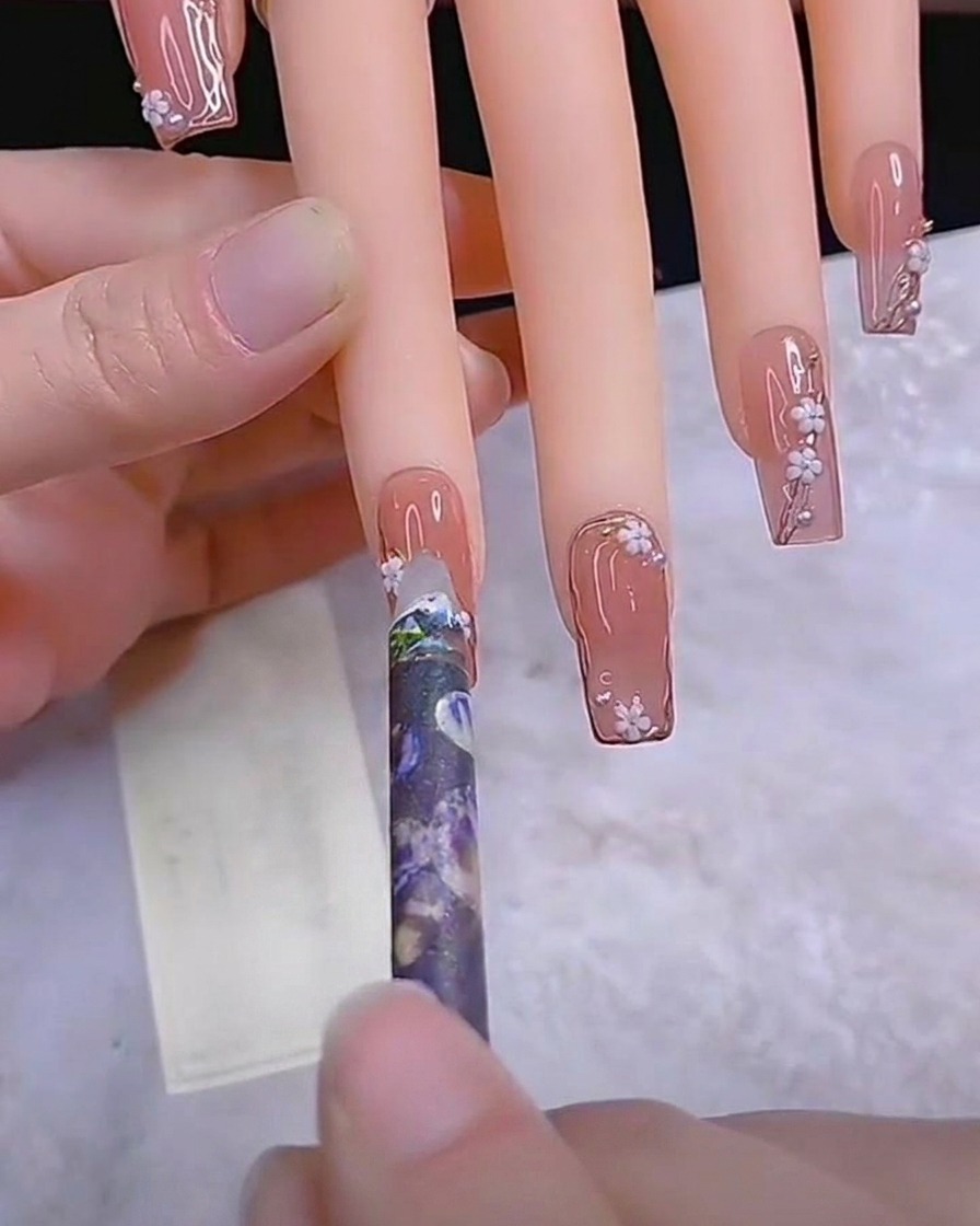 Fine liner brush painting thin stems on a nail.