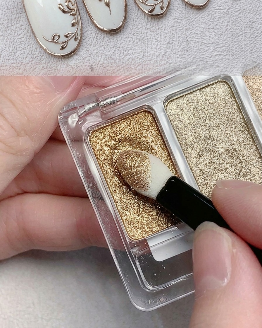 An eyeshadow sponge applicator picking up metallic gold chrome powder from a palette.