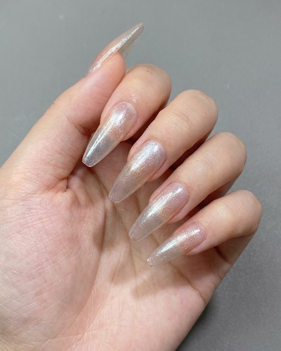 A magnet being used over a wet cat-eye gel layer to create a wide shimmering effect on the nail.