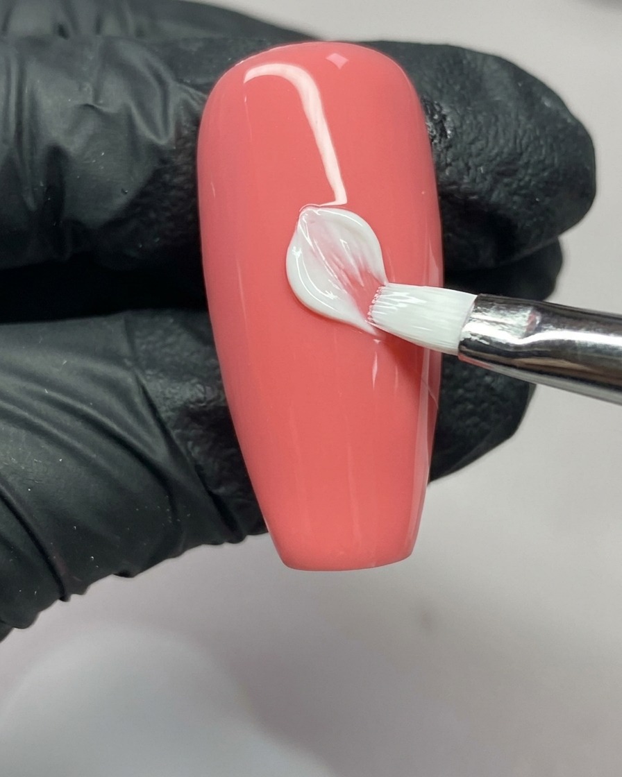 A nail art brush completing the right side of a petal, showing the V-shape at the tip.