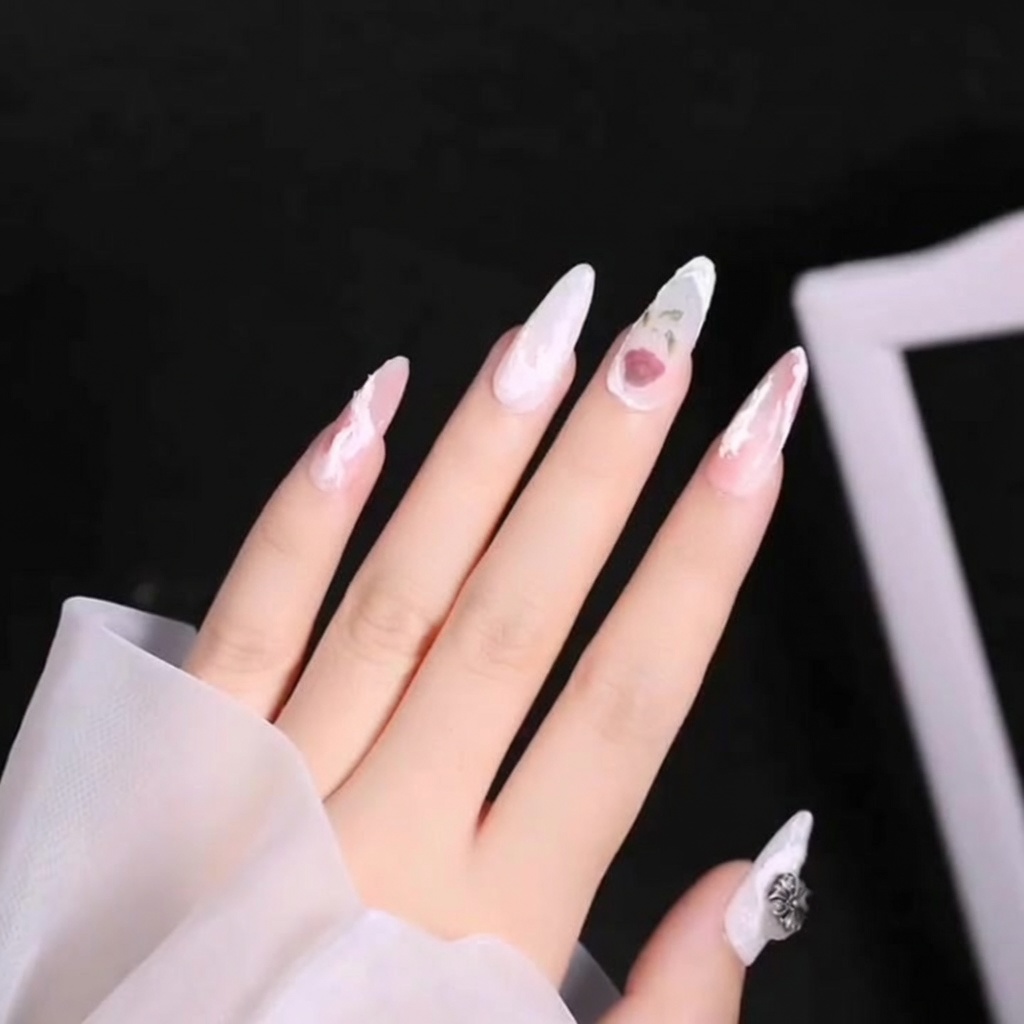 A close-up view of a detail brush adding dark green vein details to a leaf on a manicured nail.