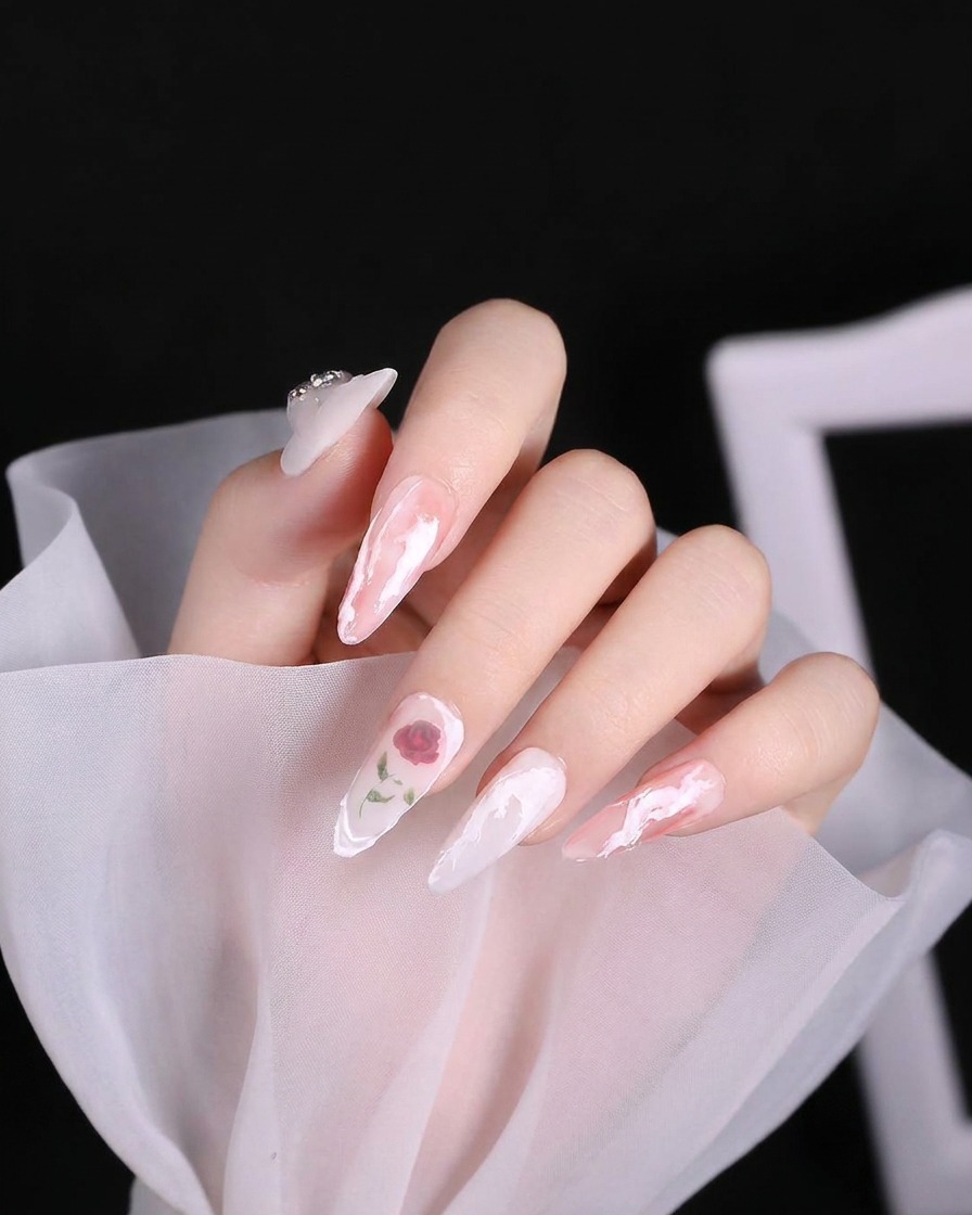 A nail art brush applying a thick, textured white gel swirl onto the cuticle area of a nail.