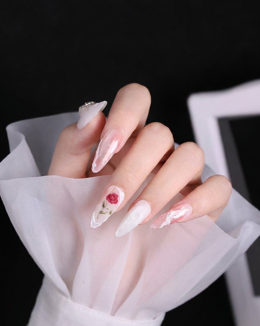 A close-up of a nail brush applying a thick, textured white line of 3D gel onto a pale pink nail.