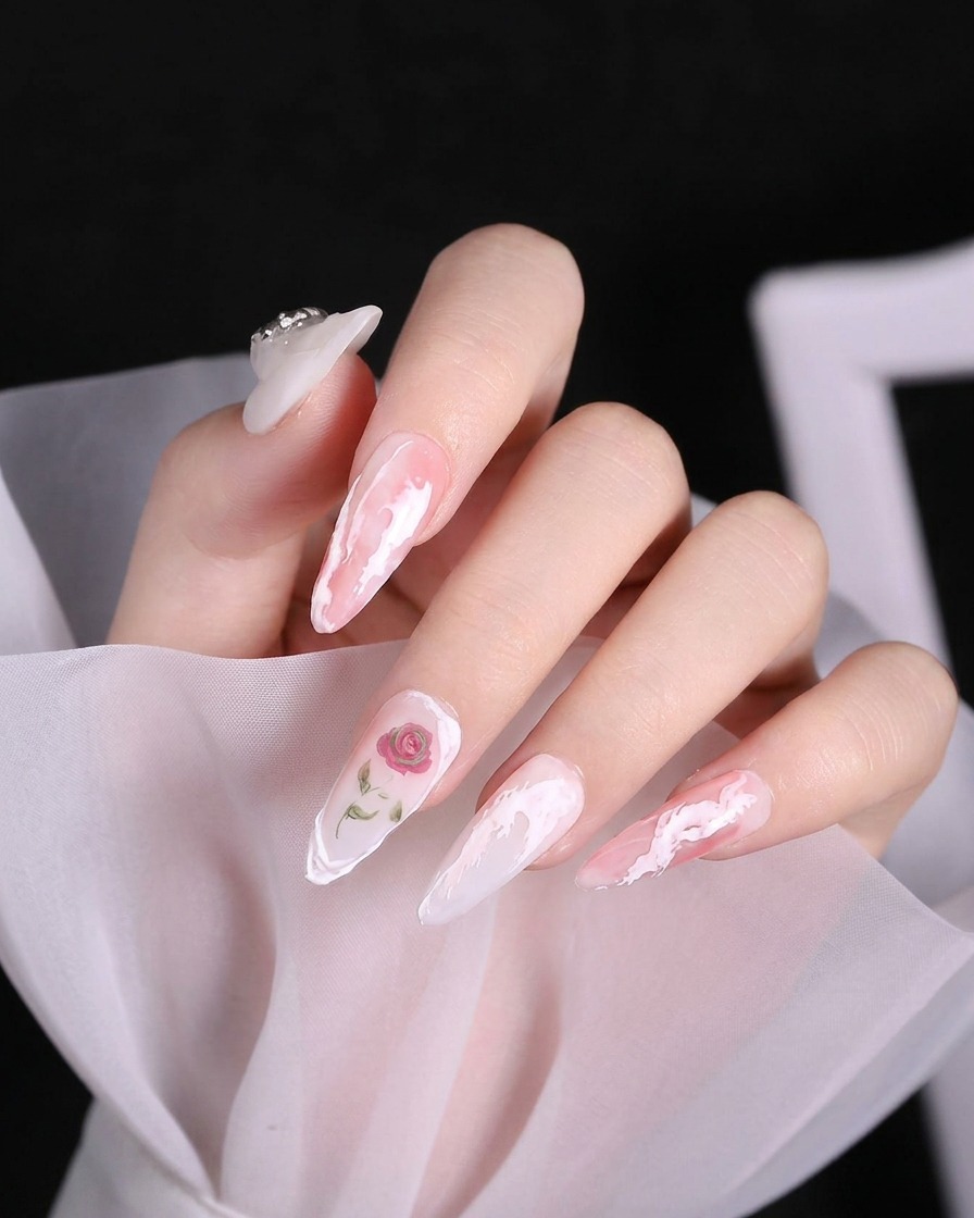 Close-up of a delicate raised white curve of 3D gel being drawn at the base of the pinky fingernail.
