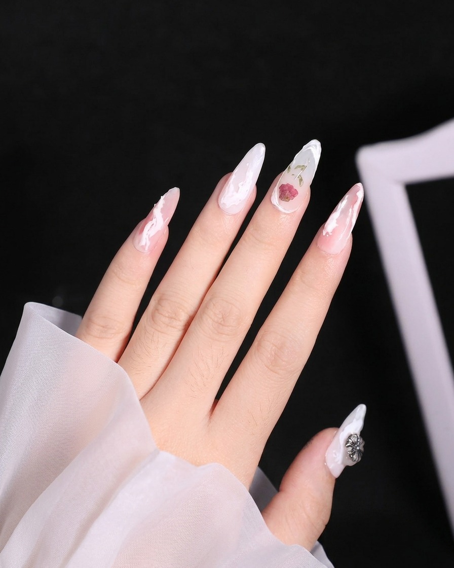 A close-up of an index finger showing the application of matte top coat on the nail base.