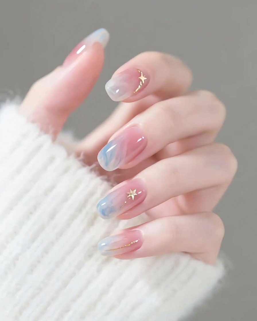 A close-up of a nail brush softly blending blue gel pigment on a natural nail surface.
