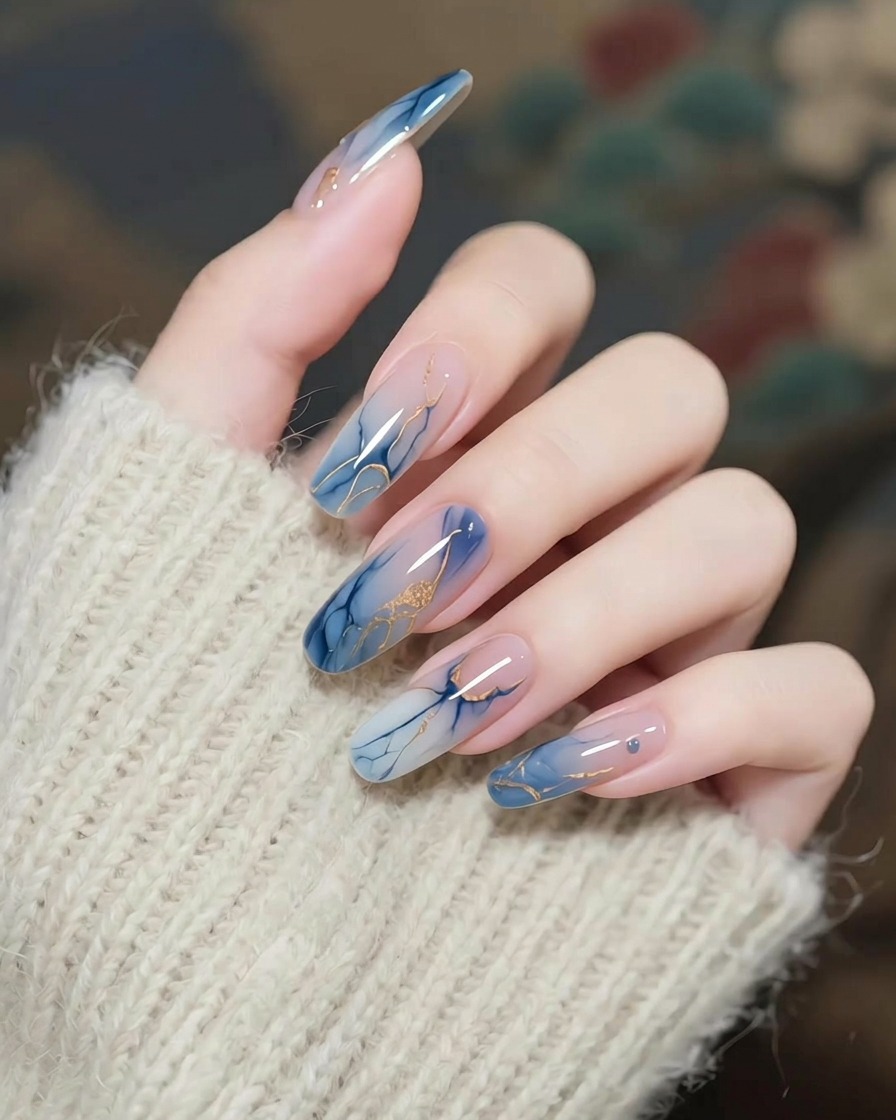 Tweezers holding a delicate gold star charm just above a nail.