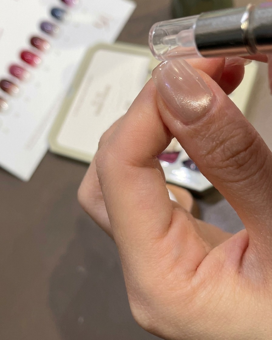 A cylindrical magnet being held near a nail to pull the magnetic shimmer into a cat-eye effect.