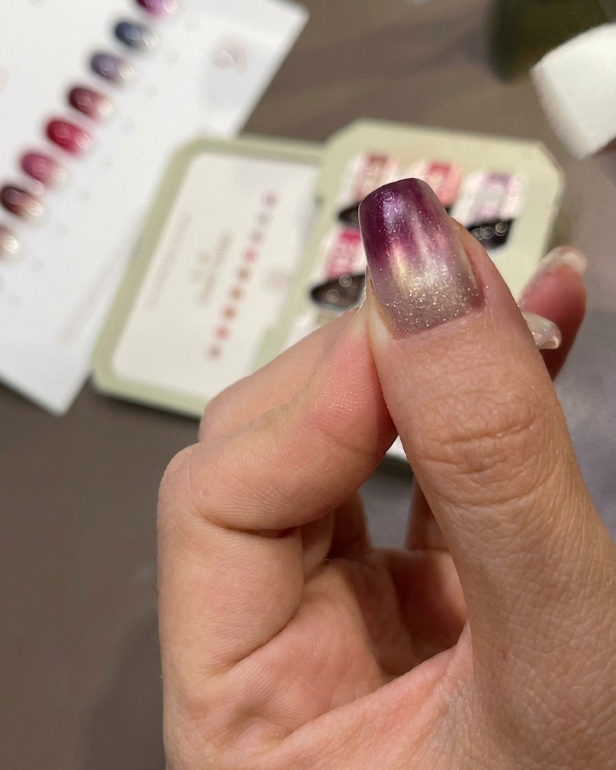 A sponge dabbing purple gel onto the nail to create a gradient effect.