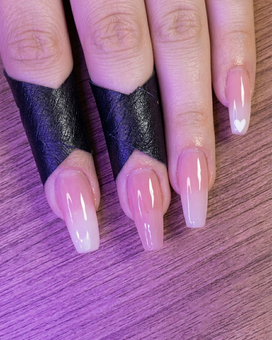 A view of fingers with nude-colored nails placed inside a nail lamp.