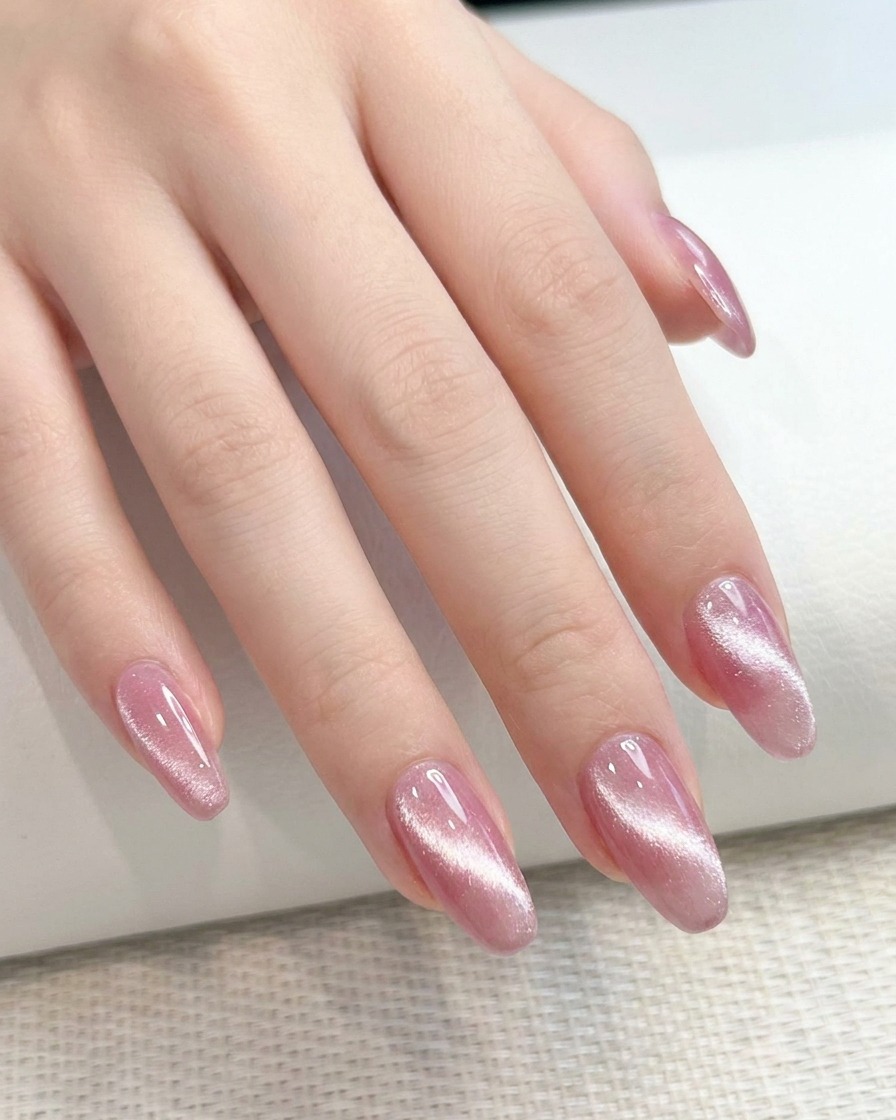 A close-up showing a rectangular magnet being held near the side of a fingernail.