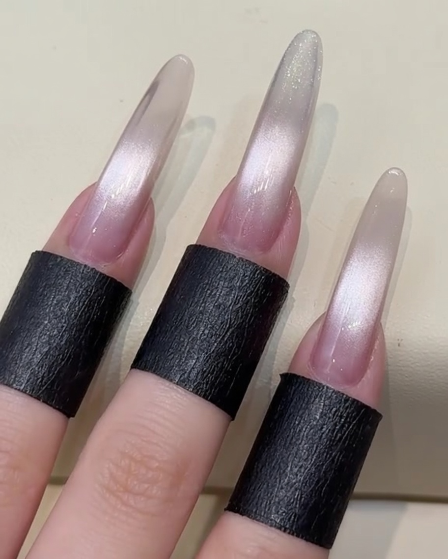 An applicator tool buffing shimmering aurora chrome powder onto the tip section of the nail.