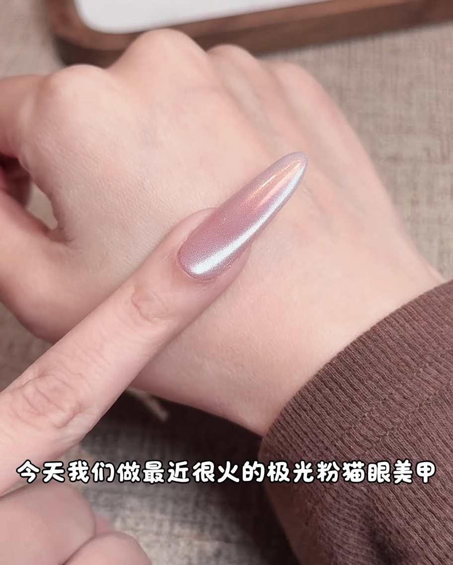 A makeup sponge applying pink pigment to the center of a nude gel nail, creating a soft, diffused gradient.