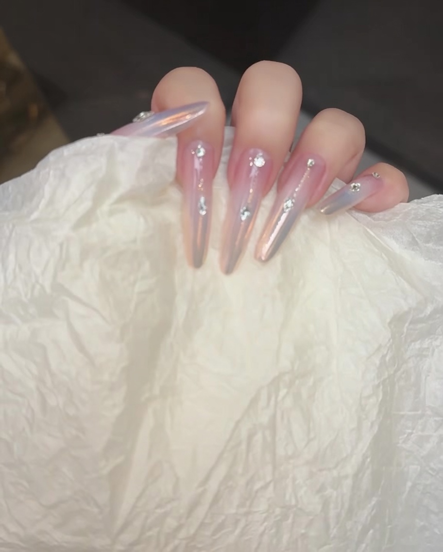 A nail brush applying a soft blushing gel to the middle of the nail.