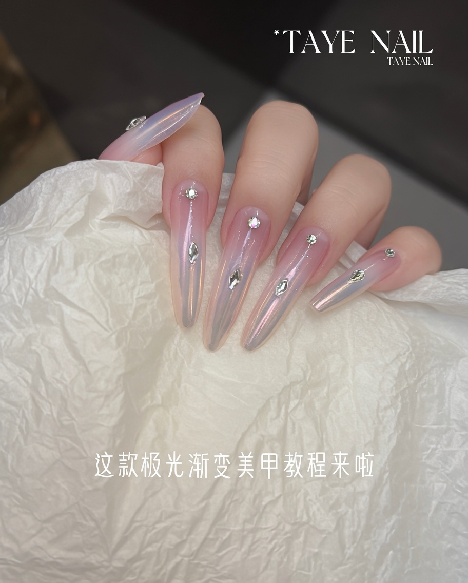 An applicator rubbing iridescent aurora chrome powder onto the tip of the nail.