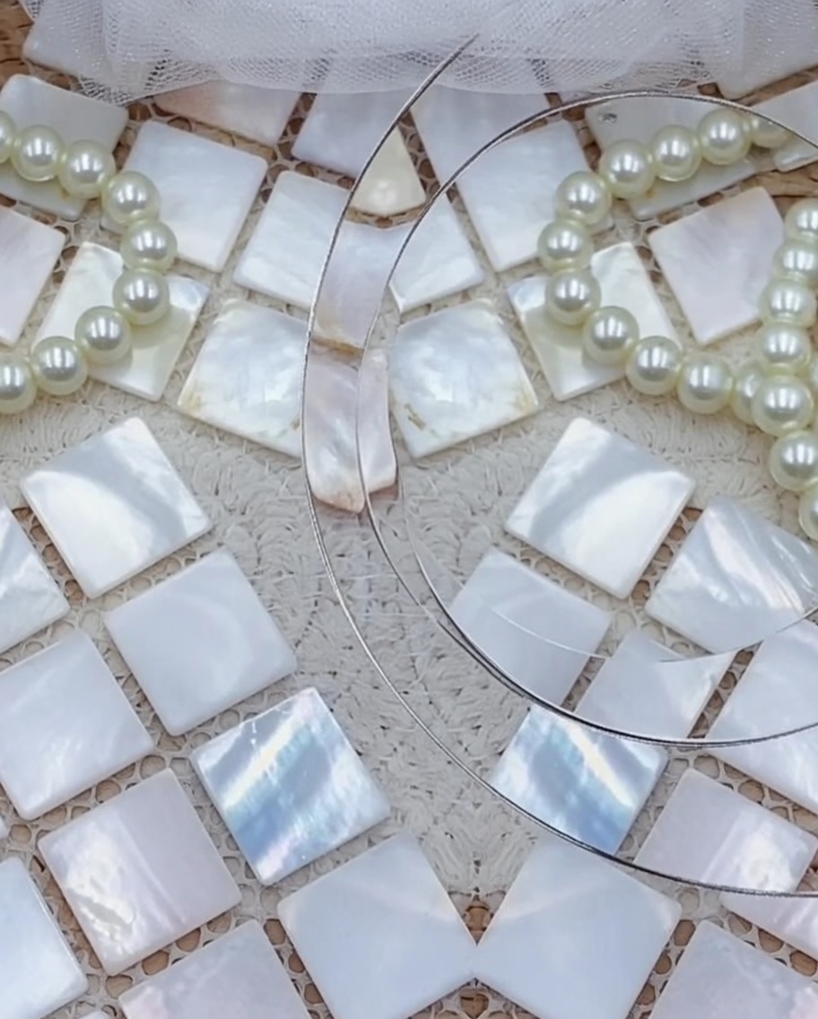 A close-up of the underside of a decorated press-on nail with a clear jelly adhesive sticker being applied.