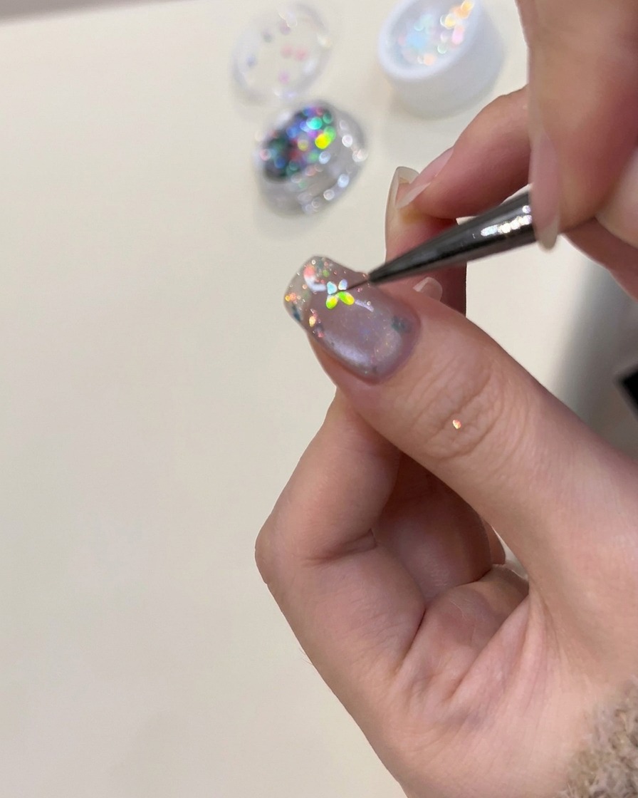 A close-up view of a finger resting under a UV nail lamp during the curing process.