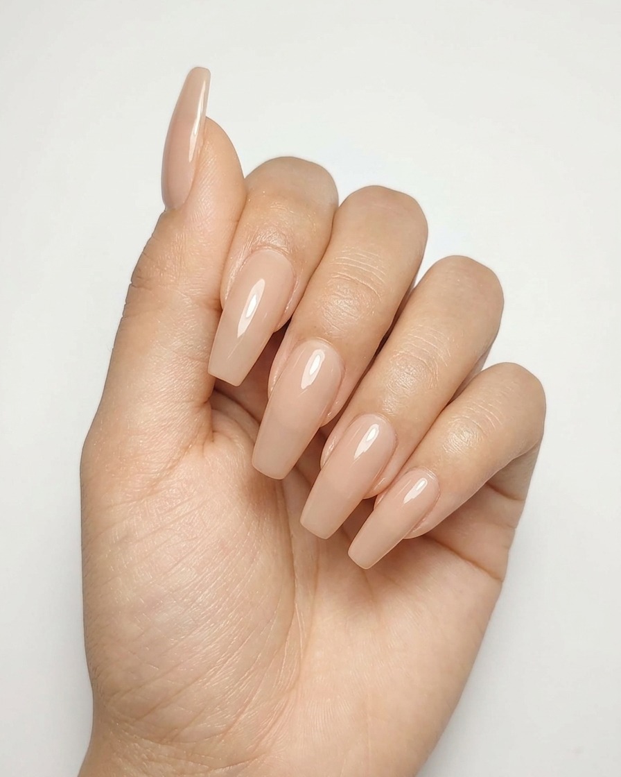 A close-up of a nude gel nail with a completed metallic silver star design being cured under a lamp.
