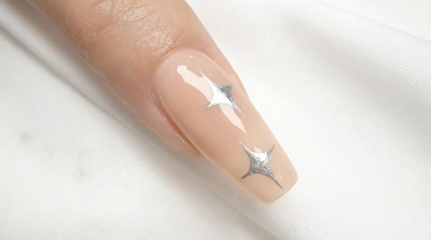 Minimalist hand-painted metallic silver star design over a clean, high-gloss nude gel base.