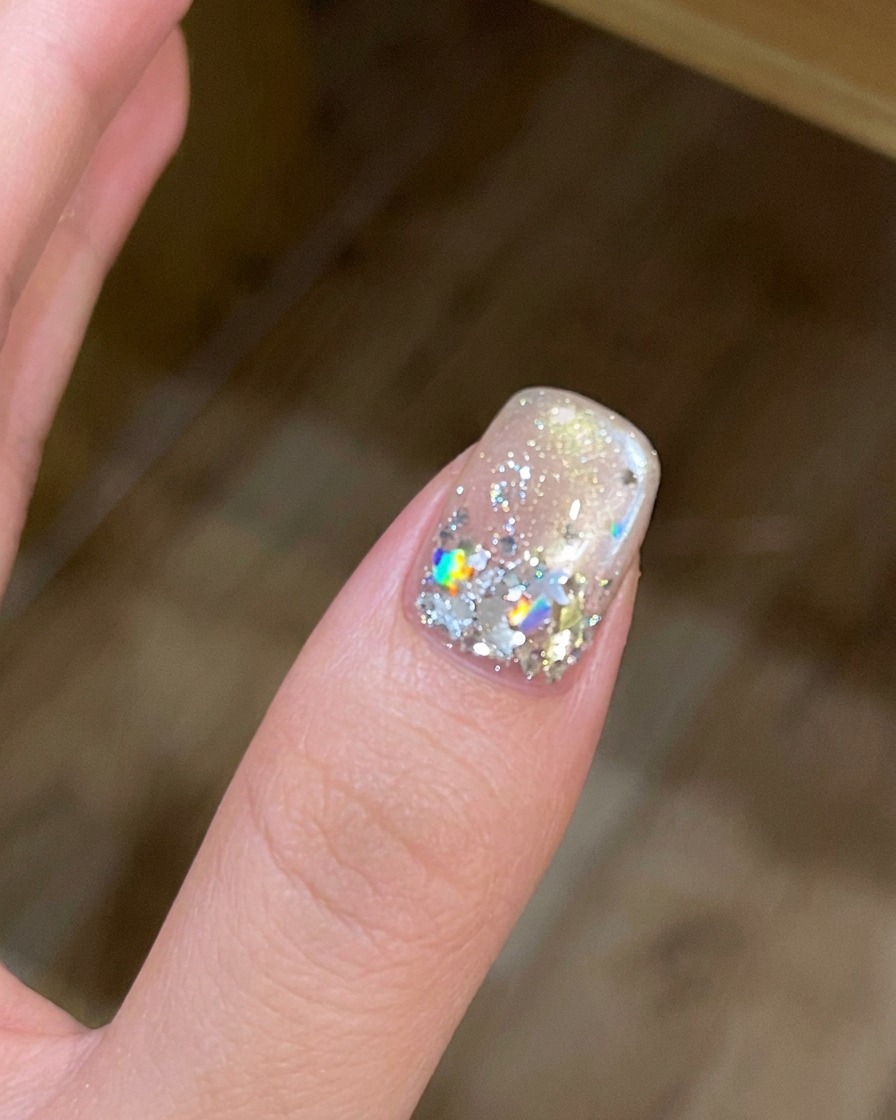 A hand inside a UV/LED nail lamp with the light activated.