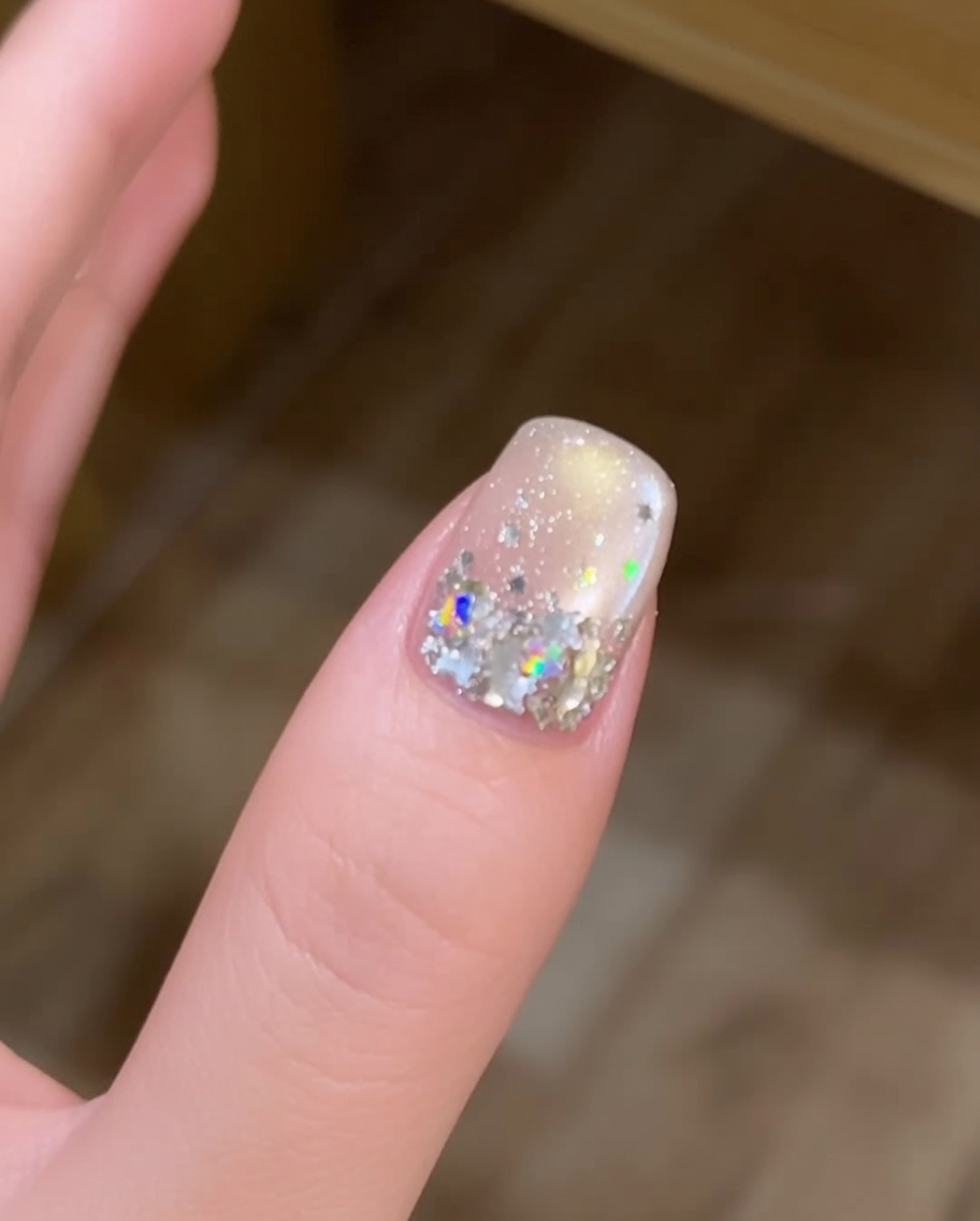 A long nail brush applying a fresh, rounded bead of clear builder gel to the center of a fingernail.