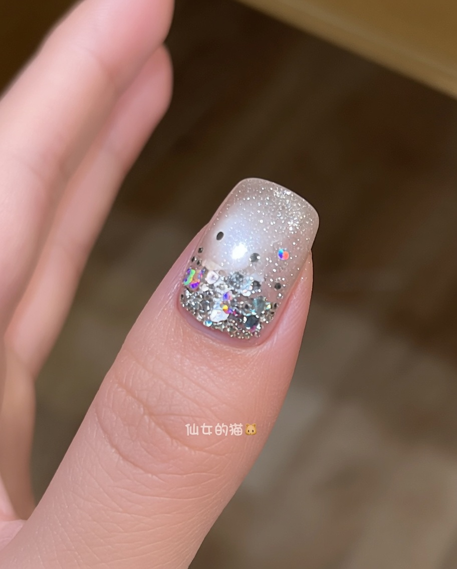 A brush applying a final layer of glossy, clear top coat over a star-decorated nail.