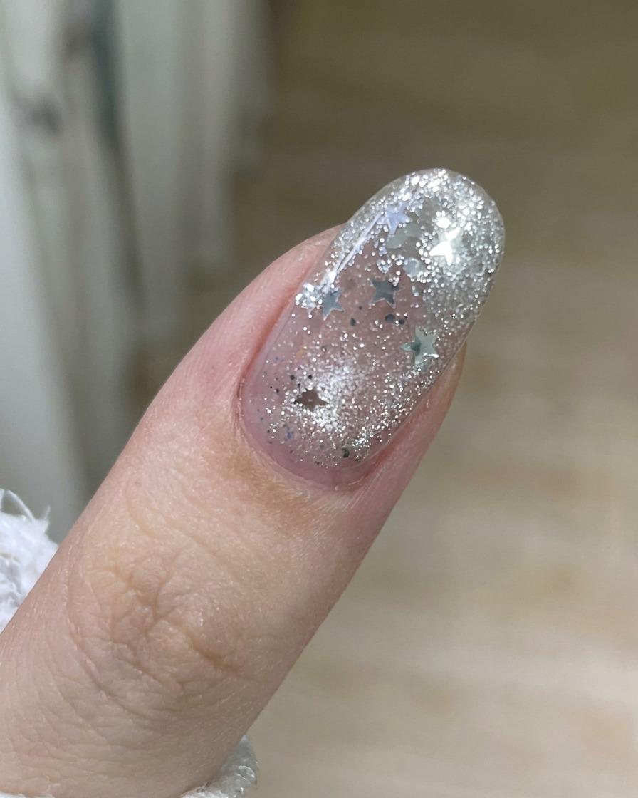 A hand pulling a strip of old gel polish cleanly off the surface of a fingernail.