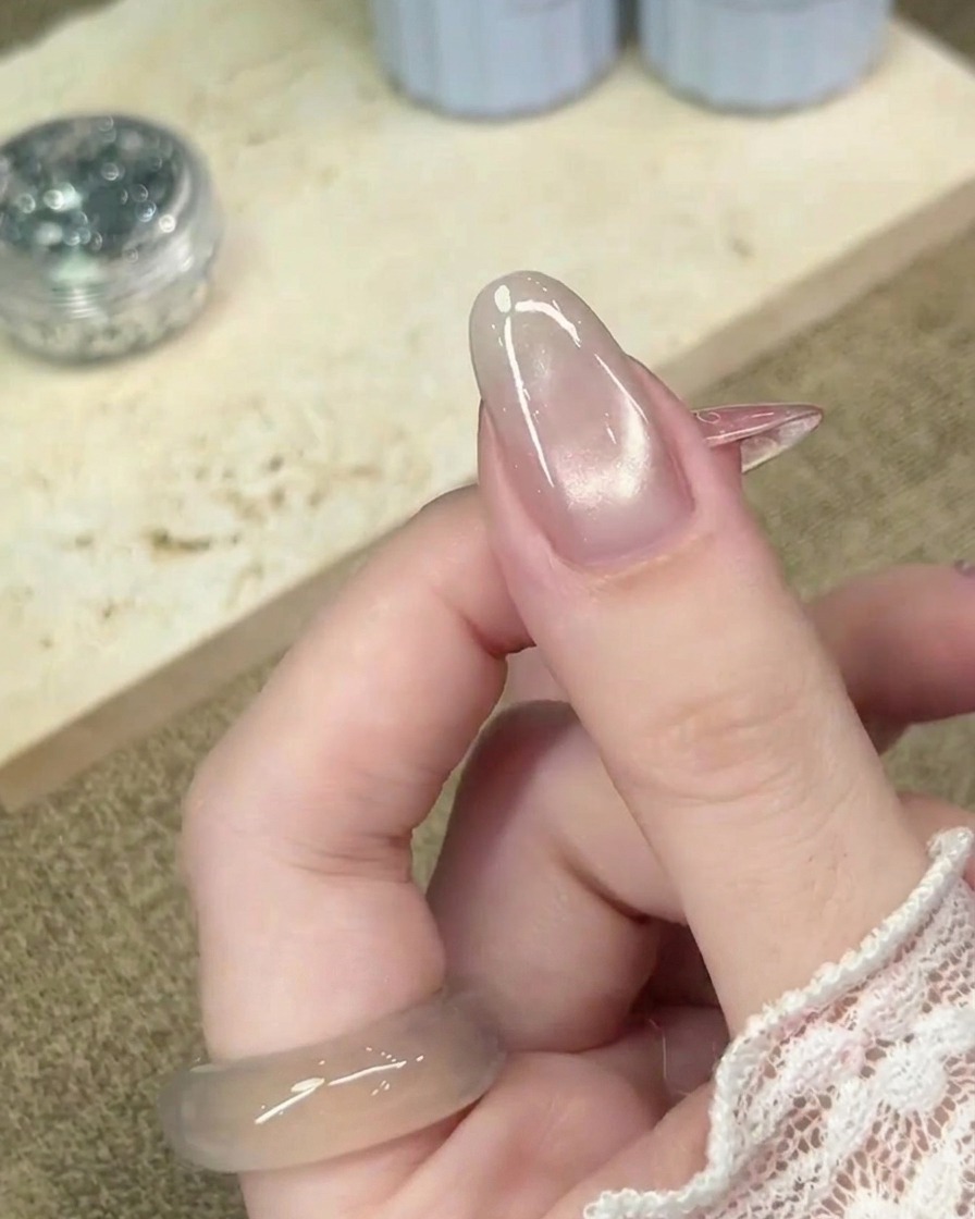 A close-up view of a cured cat-eye gel nail, showing a smooth and finished surface texture.