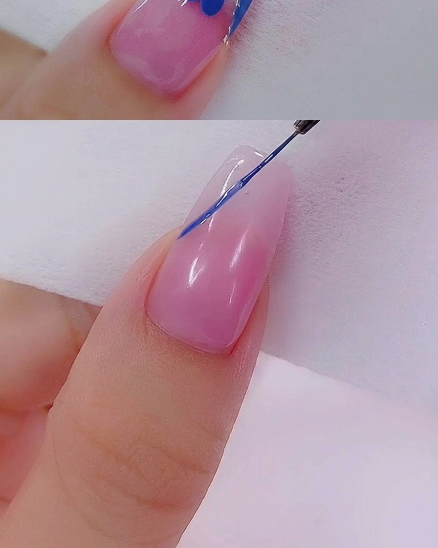 A gel brush applying a second layer of blue polish to the French tip for even coverage.