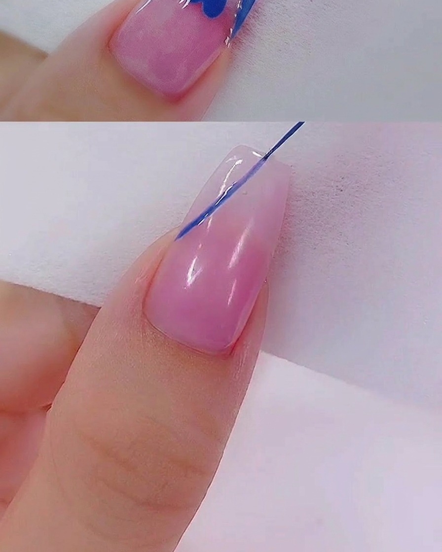 A liner brush carefully pulling blue gel into a heart shape on the nail surface.