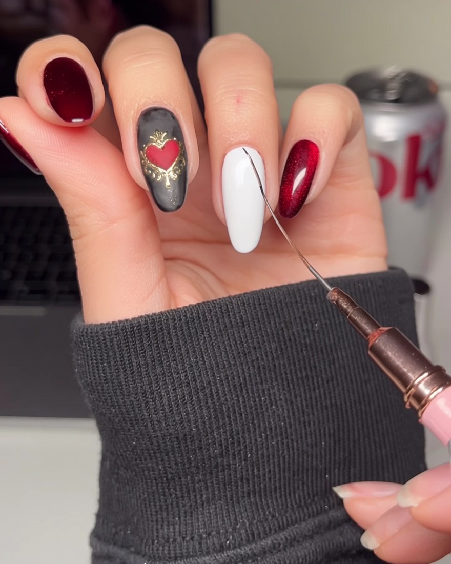 A close-up of a white-painted nail being decorated with thin black diagonal lines to form a grid.