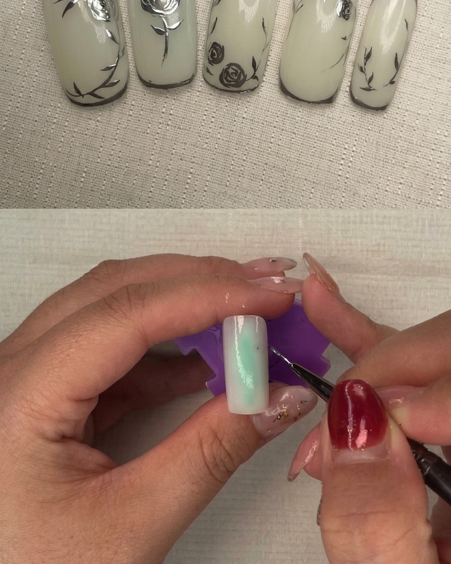 A nail with a second layer of milky white polish being cured under a nail lamp.