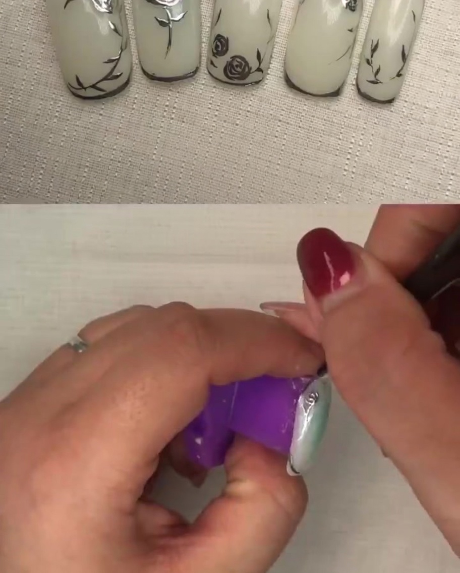 A hand inside a UV/LED lamp during the curing process for the final nail design.