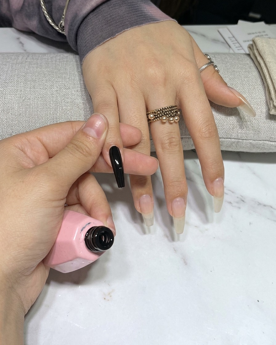 A hand inside a UV nail lamp, with the nails under the light.