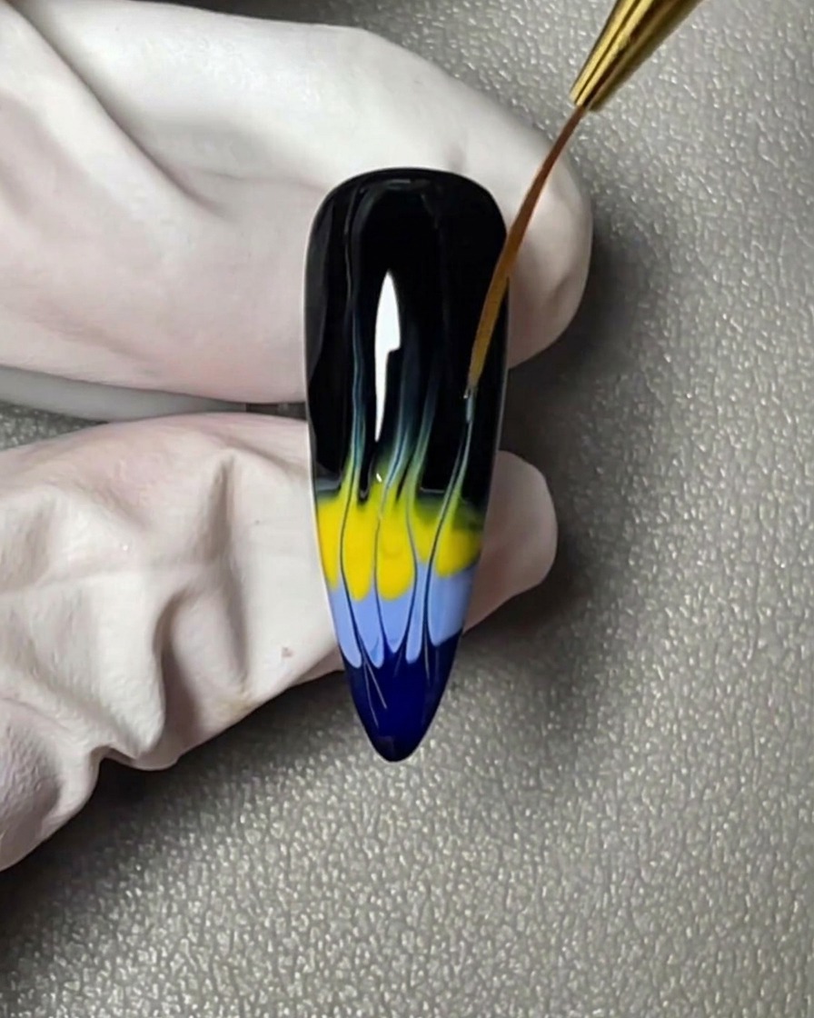 A horizontal stripe of yellow gel polish applied directly above the blue band on the nail tip.
