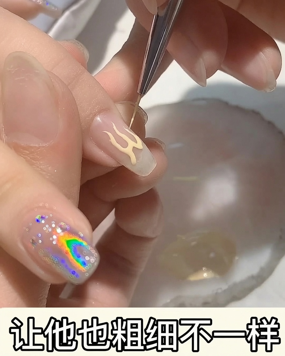A close-up of a flame design on a nail being thickened with peach-toned gel polish.