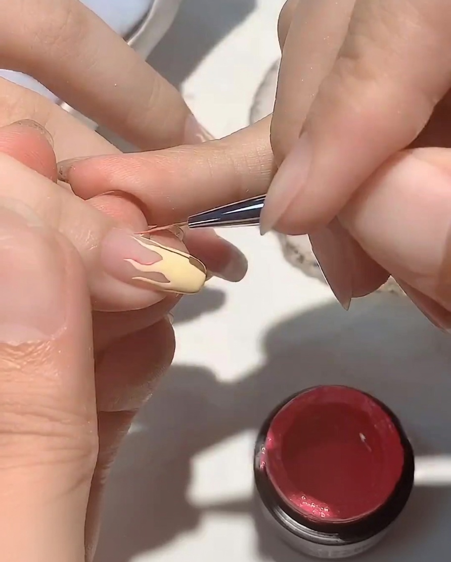 A close-up of a hand resting inside a UV nail lamp, with the focus on the nails being cured.