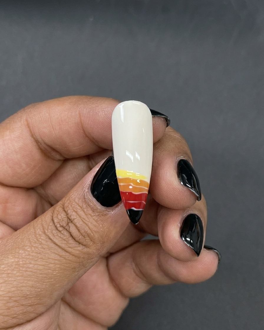 A fine liner brush applying a thin yellow stripe of gel polish to the top of the red and orange bands.