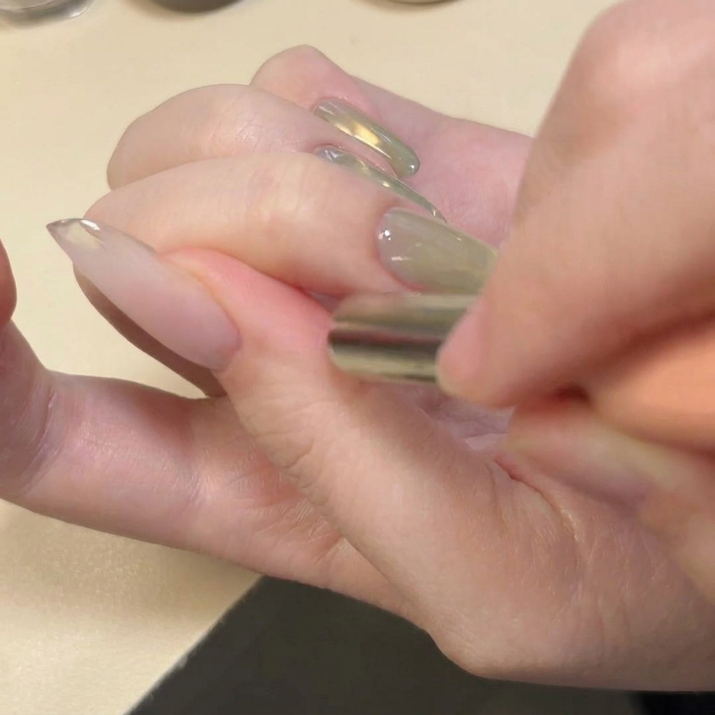 A magnet positioned horizontally across the tip of the nail to create a U-shaped glitter pattern.